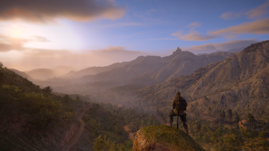 Person standing atop a mountain looking out.