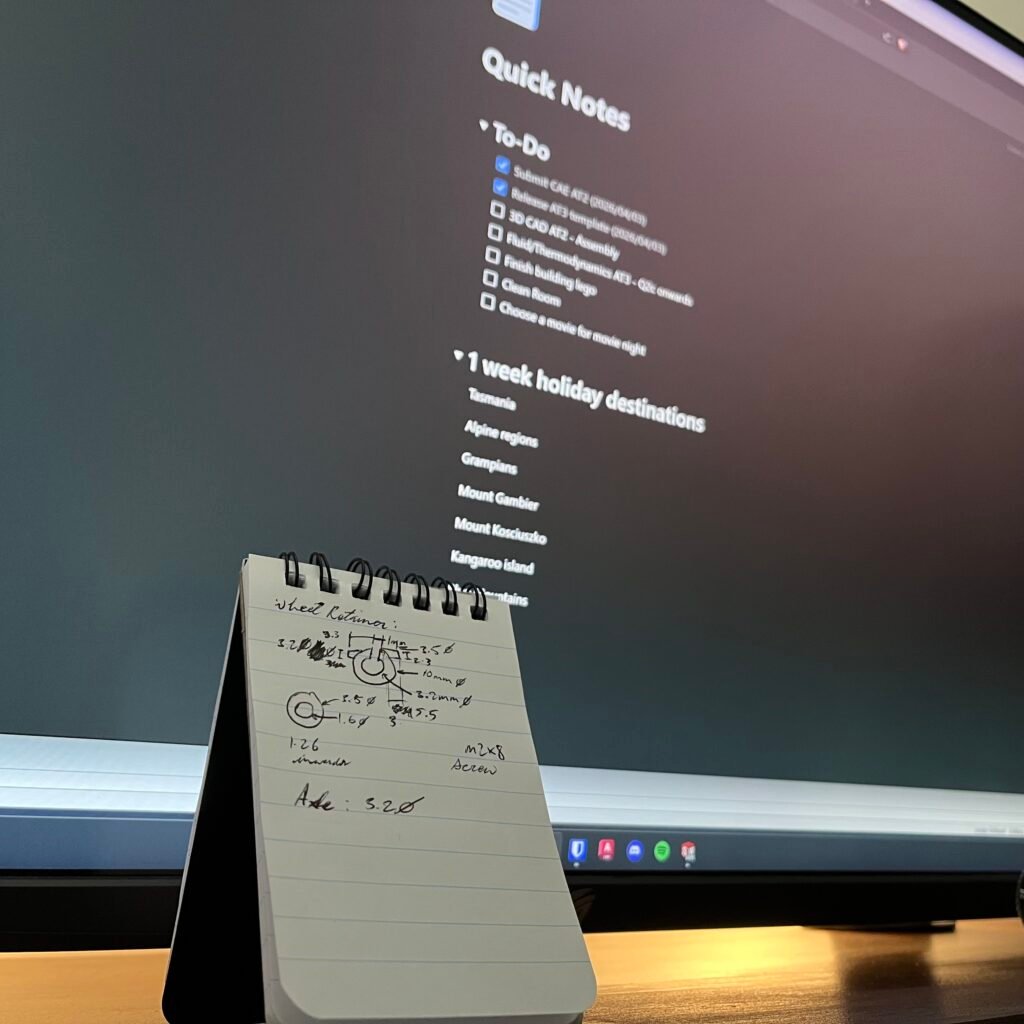 Handwritten notes on notepad and typed notes in the background.